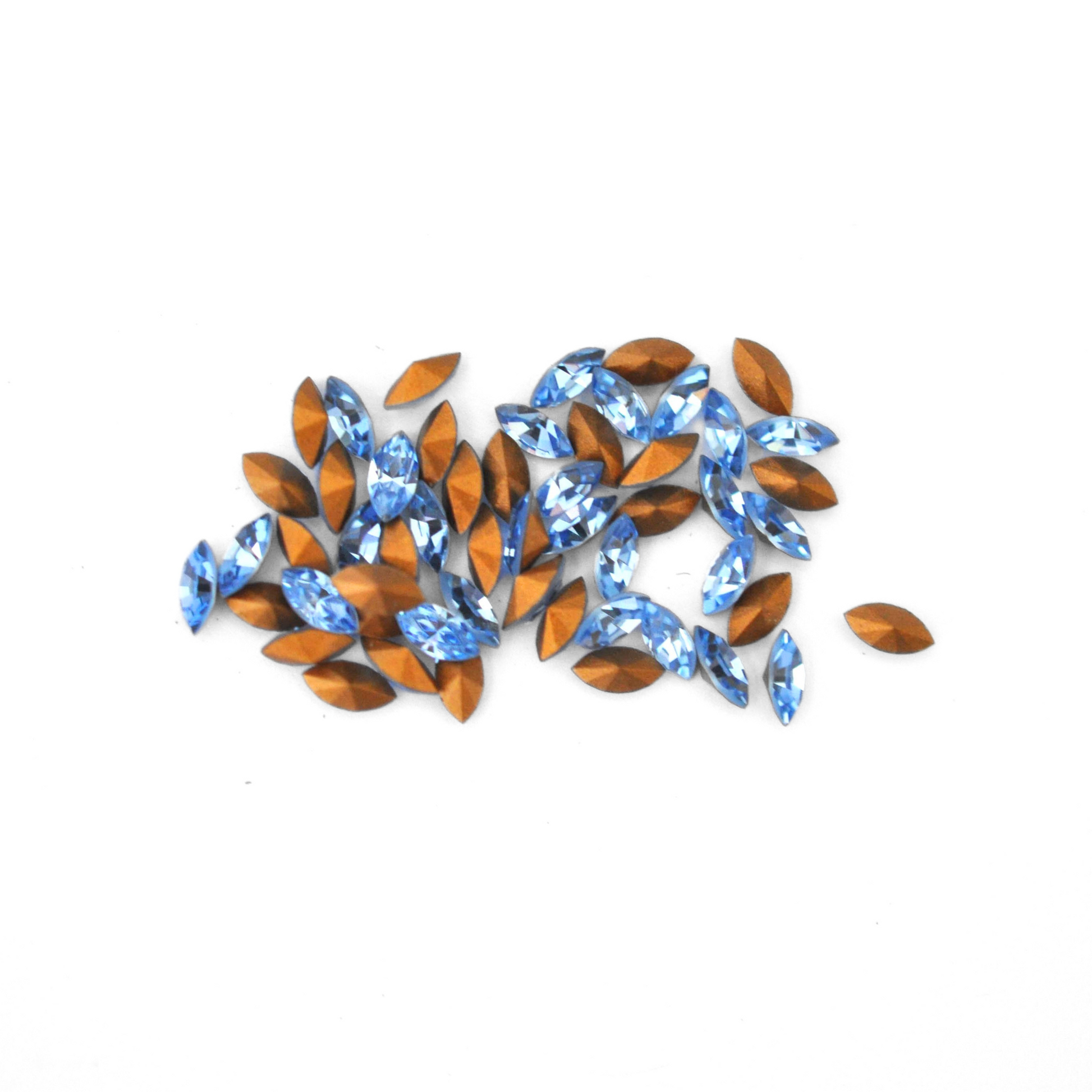 Navette shaped faceted Austrian crystal rhinestones in the color Light Sapphire displayed on a white background.