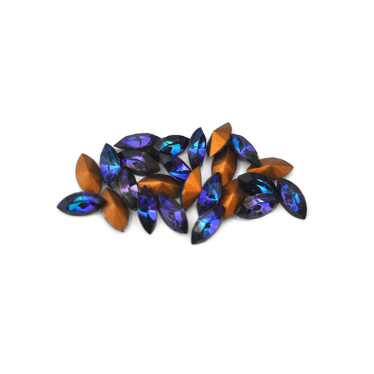 Navette shaped faceted Austrian crystal rhinestones in the color Heliotrope displayed on a white background.