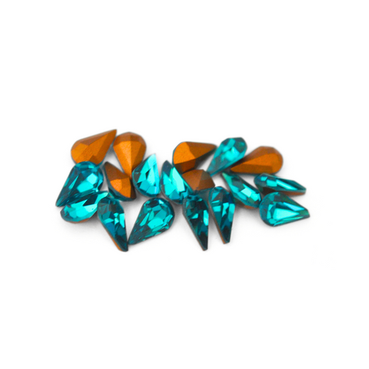 Pear shaped faceted Austrian crystal rhinestones in the color Blue Zircon displayed on a white background. 