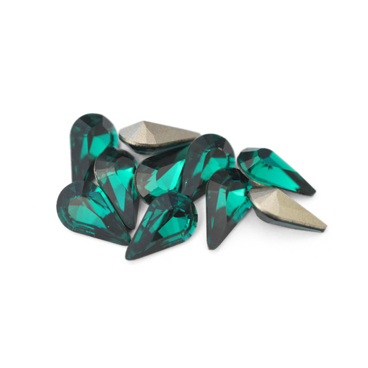 Pear shaped faceted Austrian crystal rhinestones in the color Emerald displayed on a white background. 