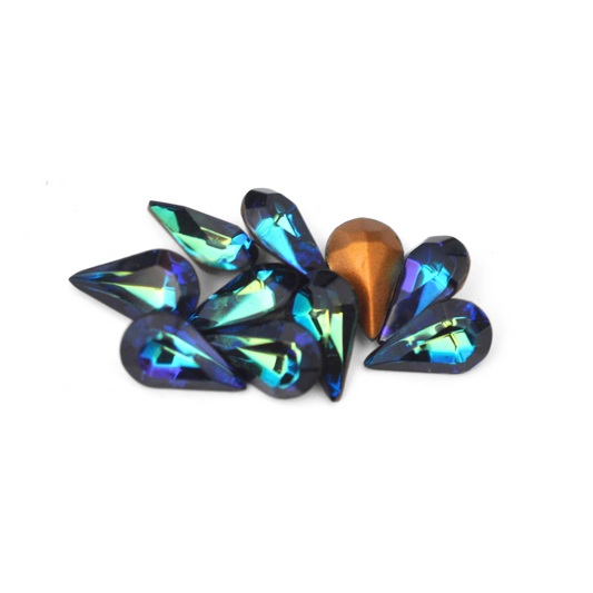 Pear shaped faceted Austrian crystal rhinestones in the color Heliotrope displayed on a white background. 