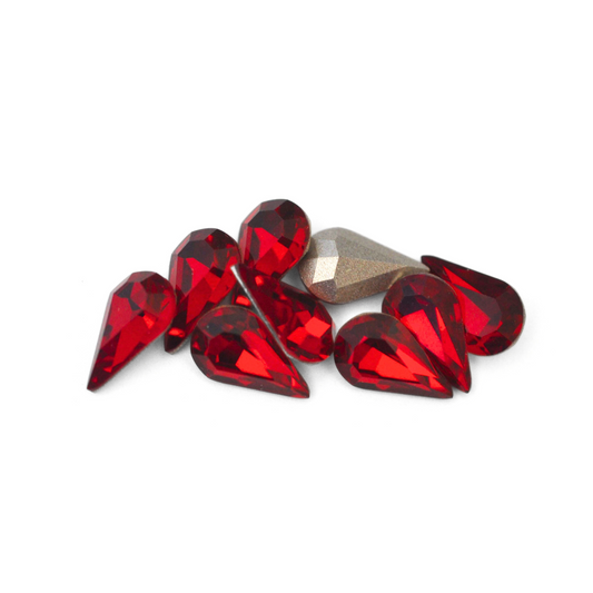 Pear shaped faceted Austrian crystal rhinestones in the color Siam displayed on a white background. 