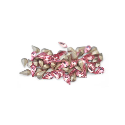 Pear shaped faceted Austrian crystal rhinestones in the color Light Rose displayed on a white background. 