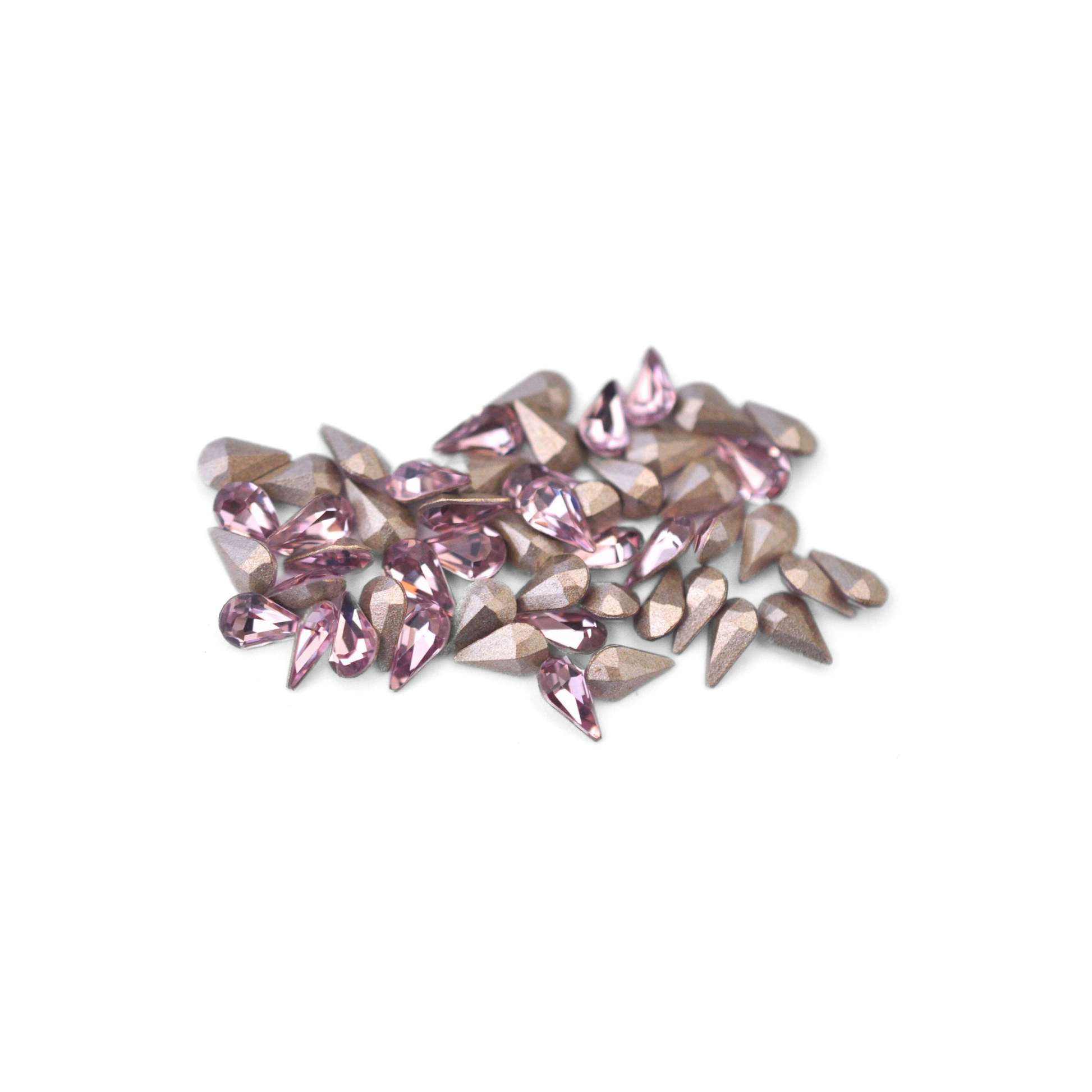 Pear shaped faceted Austrian crystal rhinestones in the color Light Amethyst displayed on a white background. 
