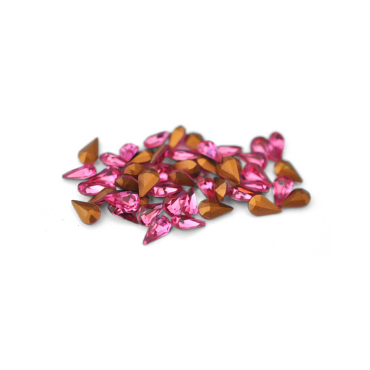 Pear shaped faceted Austrian crystal rhinestones in the color Rose displayed on a white background. 