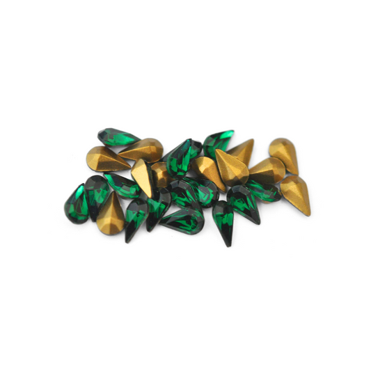 Pear shaped faceted Austrian crystal rhinestones in the color Emerald displayed on a white background. 