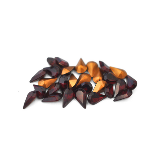 Pear shaped faceted Austrian crystal rhinestones in the color Garnet displayed on a white background. 
