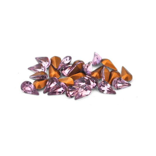 Pear shaped faceted Austrian crystal rhinestones in the color Light Amethyst displayed on a white background. 