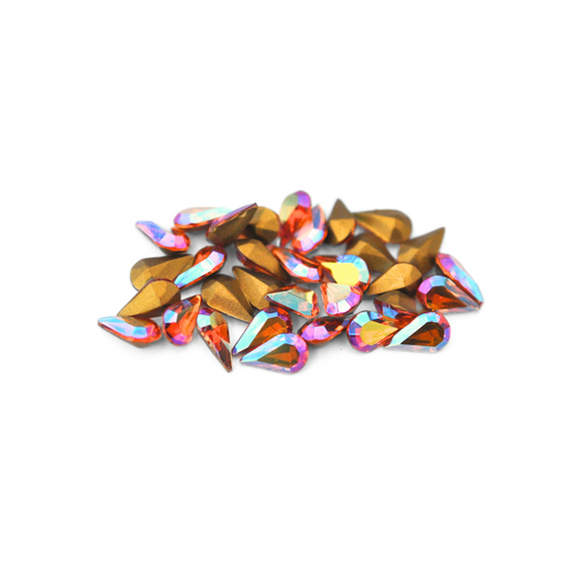 Pear shaped faceted Austrian crystal rhinestones in the color Topaz AB displayed on a white background. 