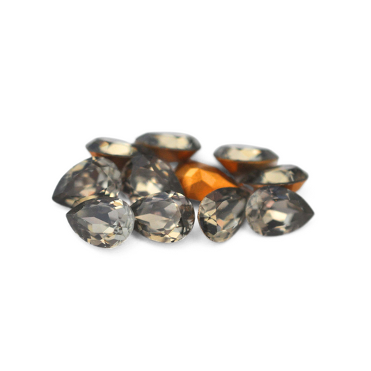 Pear shaped faceted Austrian crystal rhinestones in the color Black Diamond displayed on a white background. 