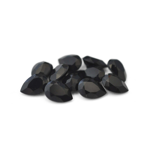 Pear shaped faceted Austrian crystal rhinestones in the color Jet displayed on a white background. 