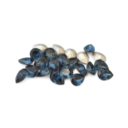 Pear shaped faceted Austrian crystal rhinestones in the color Montana displayed on a white background. 