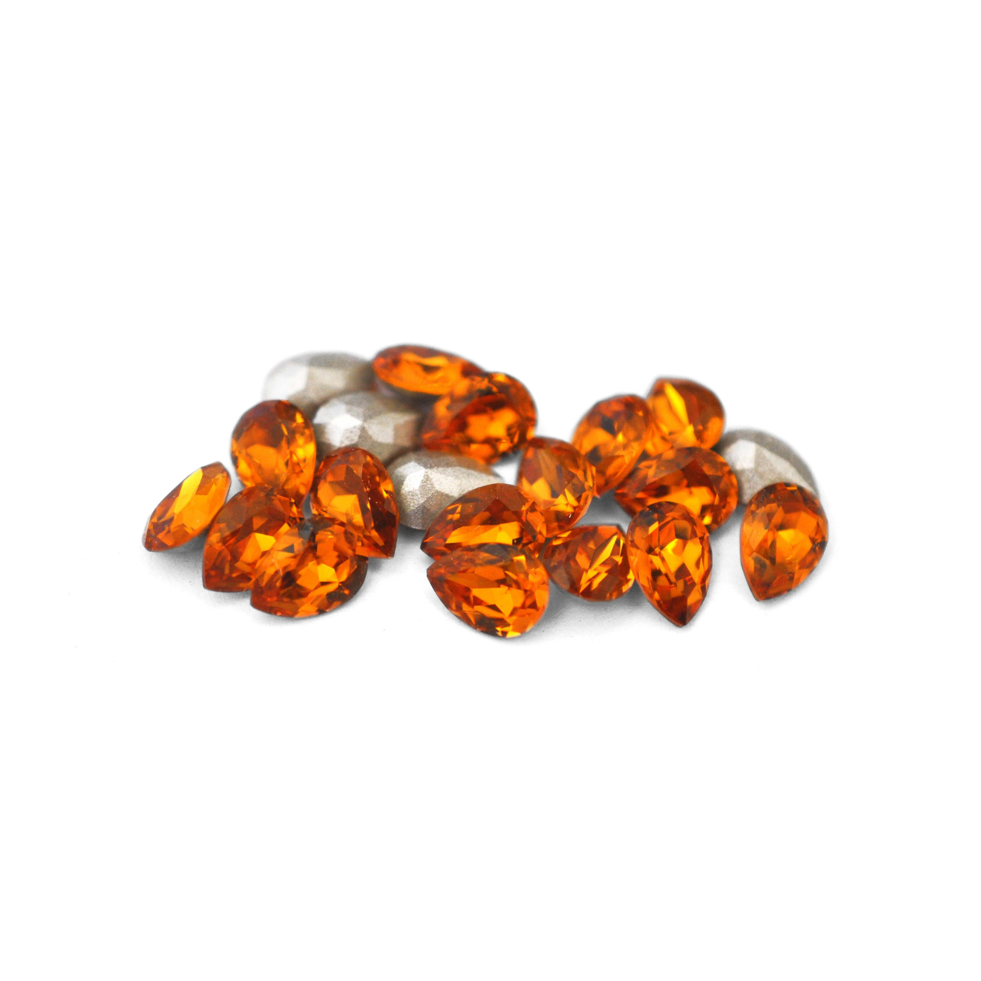 Pear shaped faceted Austrian crystal rhinestones in the color Topaz displayed on a white background. 