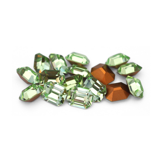 Octagon shaped faceted Austrian crystal rhinestones in the color Chrysolite displayed on a white background. 