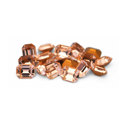 Octagon shaped faceted Austrian crystal rhinestones in the color Light Peach displayed on a white background. 