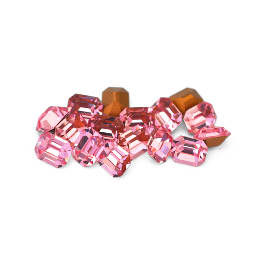 Octagon shaped faceted Austrian crystal rhinestones in the color Light Rose displayed on a white background. 