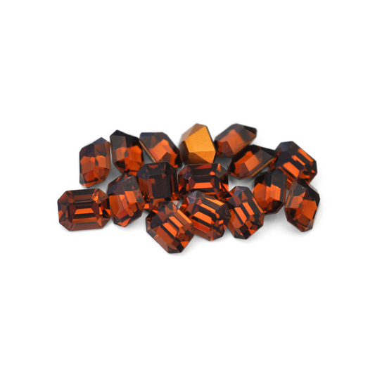 Octagon shaped faceted Austrian crystal rhinestones in the color Smoked Topaz displayed on a white background. 