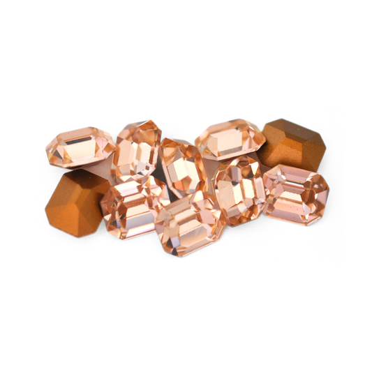 Octagon shaped faceted Austrian crystal rhinestones in the color Light Peach displayed on a white background. 
