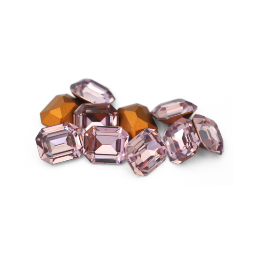Octagon shaped faceted Austrian crystal rhinestones in the color Light Amethyst displayed on a white background. 