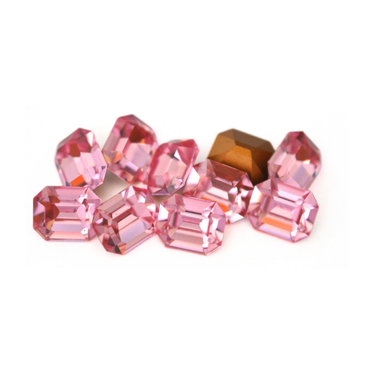 Octagon shaped faceted Austrian crystal rhinestones in the color Light Rose displayed on a white background. 