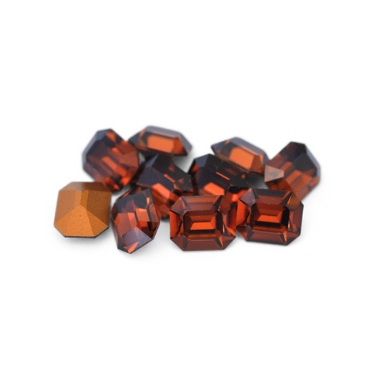 Octagon shaped faceted Austrian crystal rhinestones in the color Smoked Topaz displayed on a white background. 