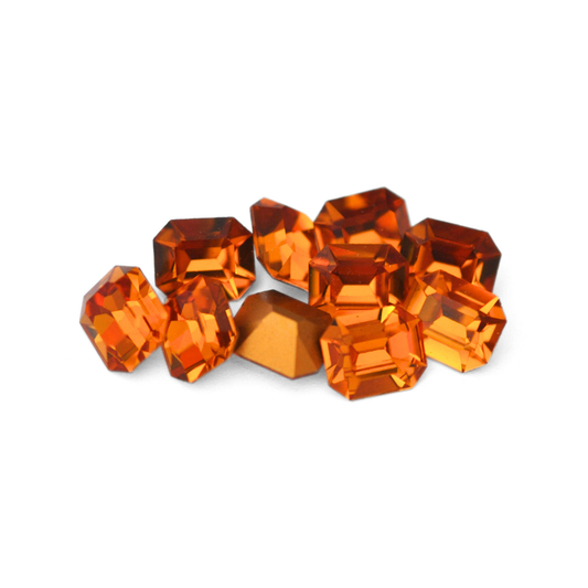 Octagon shaped faceted Austrian crystal rhinestones in the color Topaz displayed on a white background. 