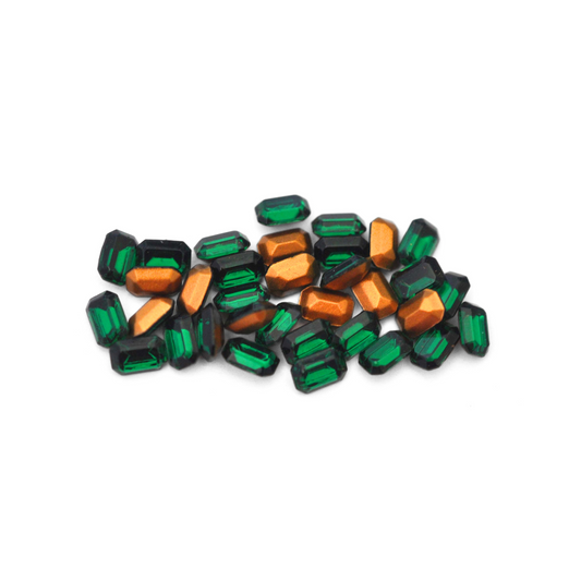 Octagon shaped faceted Austrian crystal rhinestones in the color Emerald displayed on a white background. 