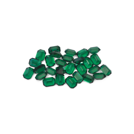 Octagon shaped faceted Austrian crystal rhinestones in the color Emerald displayed on a white background. 