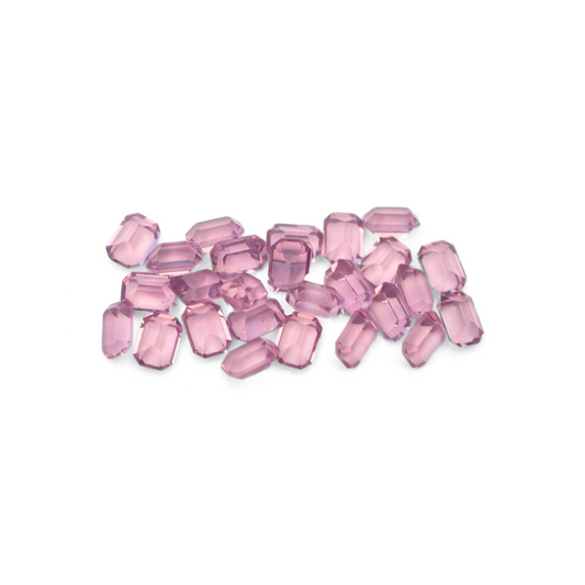 Octagon shaped faceted Austrian crystal rhinestones in the color Light Amethyst displayed on a white background. 