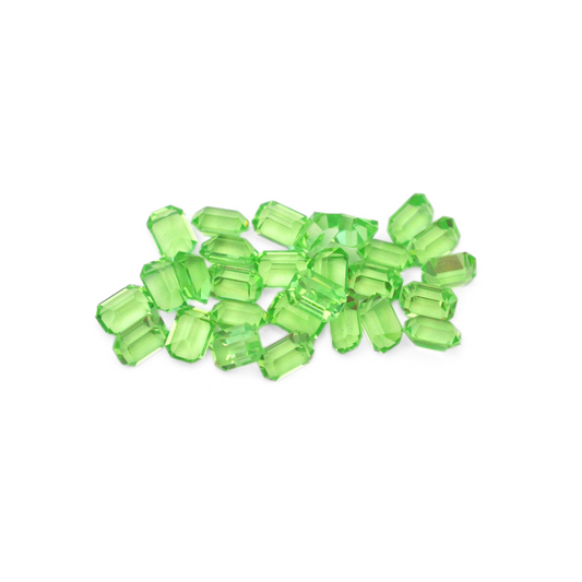 Octagon shaped faceted Austrian crystal rhinestones in the color Peridot displayed on a white background. 