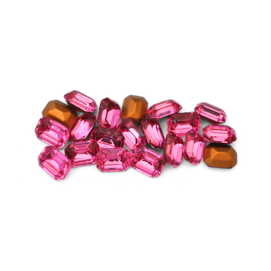 Octagon shaped faceted Austrian crystal rhinestones in the color Rose displayed on a white background. 