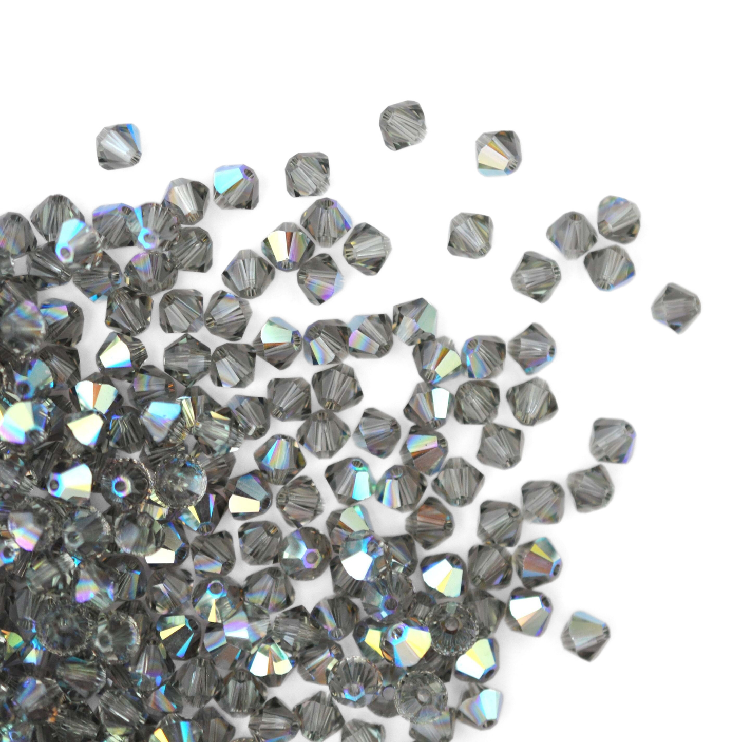 Austrian crystal 5328 bicone beads in the color Black Diamond AB spilling out onto a white background. 
