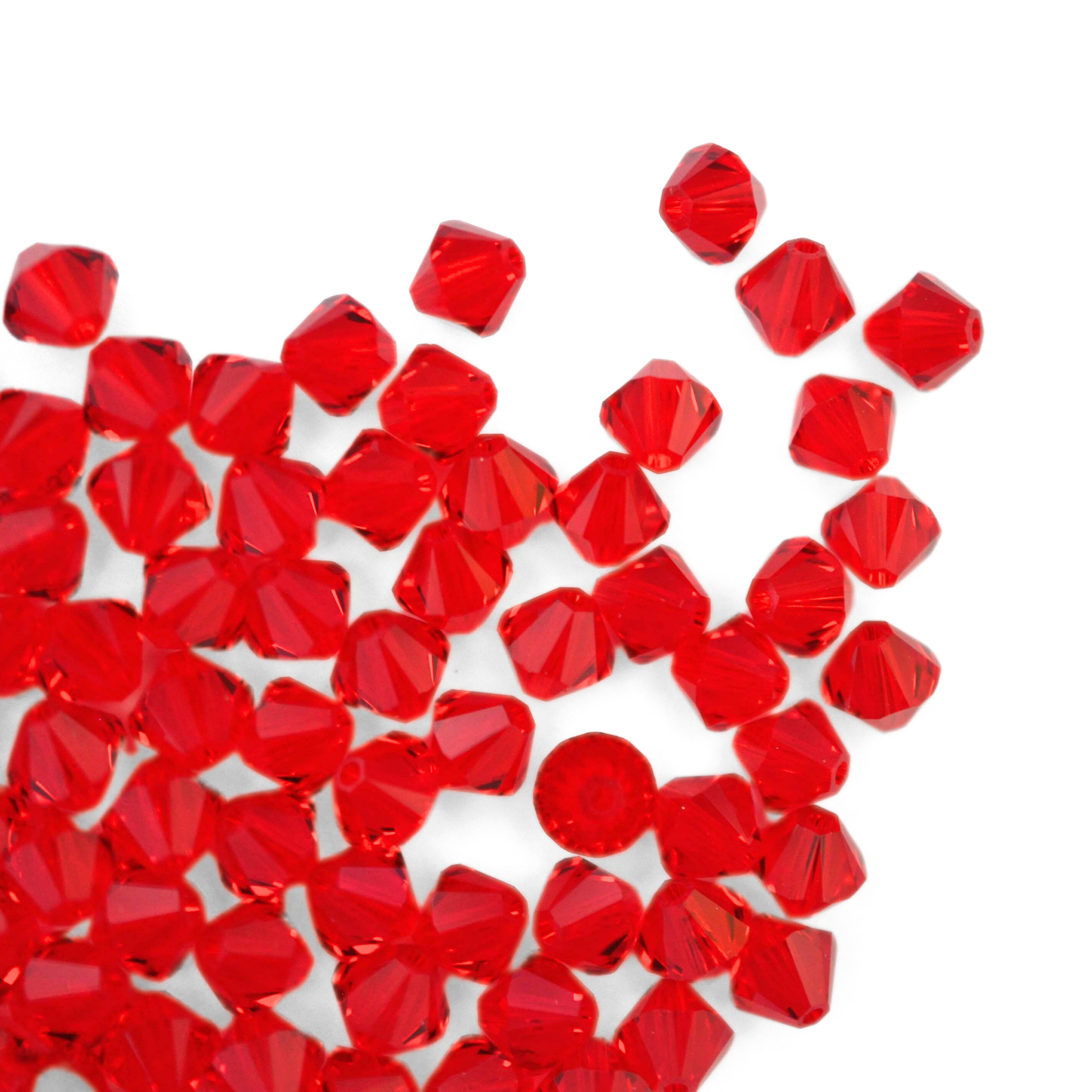 Austrian crystal 5328 bicone beads in the color Light Siam spilling out onto a white background. 