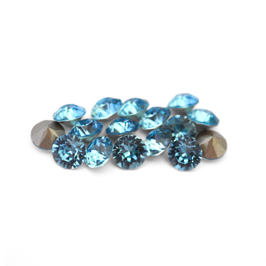 Round faceted Austrian crystal rhinestones in the color Aquamarine displayed on a white background