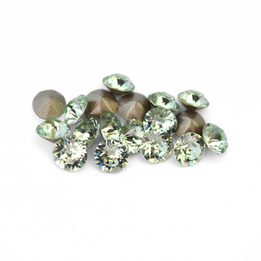 Round faceted Austrian crystal rhinestones in the color Chrysolite displayed on a white background