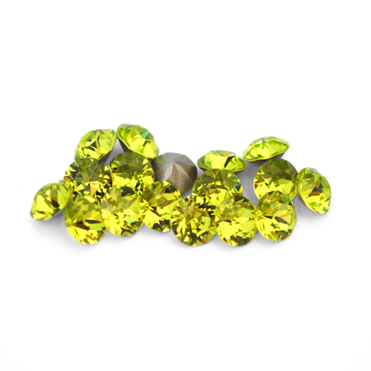 Round faceted Austrian crystal rhinestones in the color Citrus Green displayed on a white background