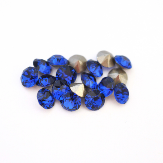 Round faceted Austrian crystal rhinestones in the color Dark Sapphire displayed on a white background