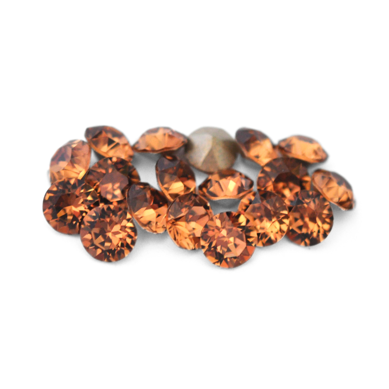 Round faceted Austrian crystal rhinestones in the color Light Smoked Topaz displayed on a white background