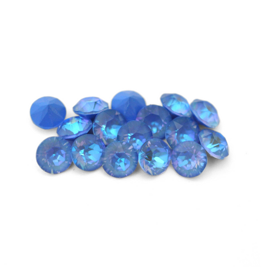 Round faceted Austrian crystal rhinestones in the color Ocean Delite displayed on a white background