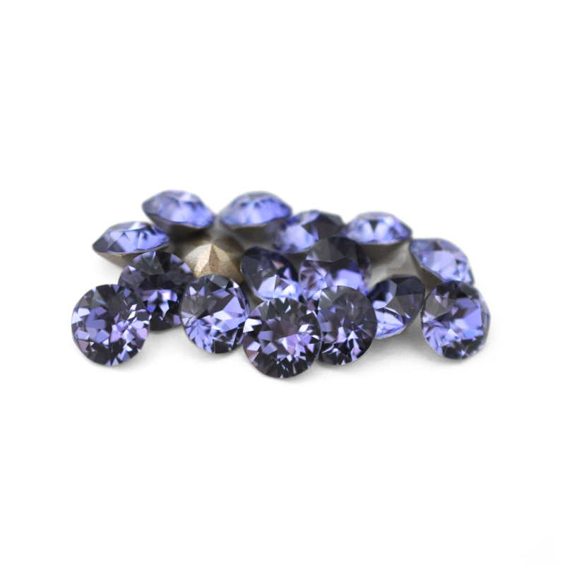Round faceted Austrian crystal rhinestones in the color Tanzanite displayed on a white background