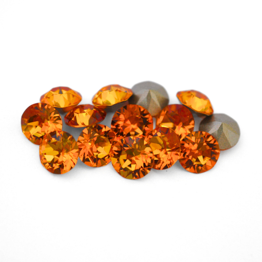 Round faceted Austrian crystal rhinestones in the color Dark Orange displayed on a white background