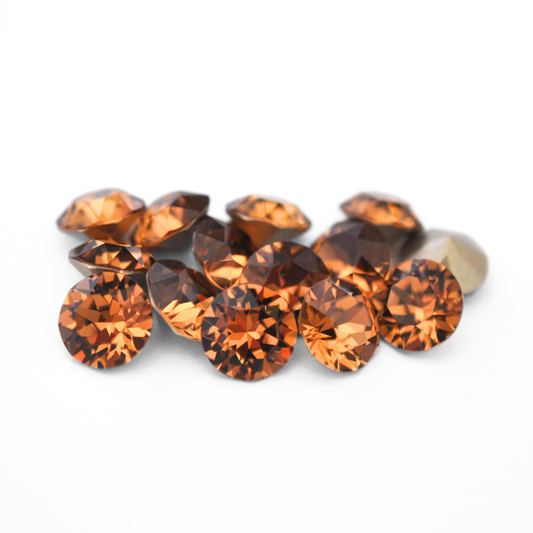 Round faceted Austrian crystal rhinestones in the color Light Smoked Topaz displayed on a white background